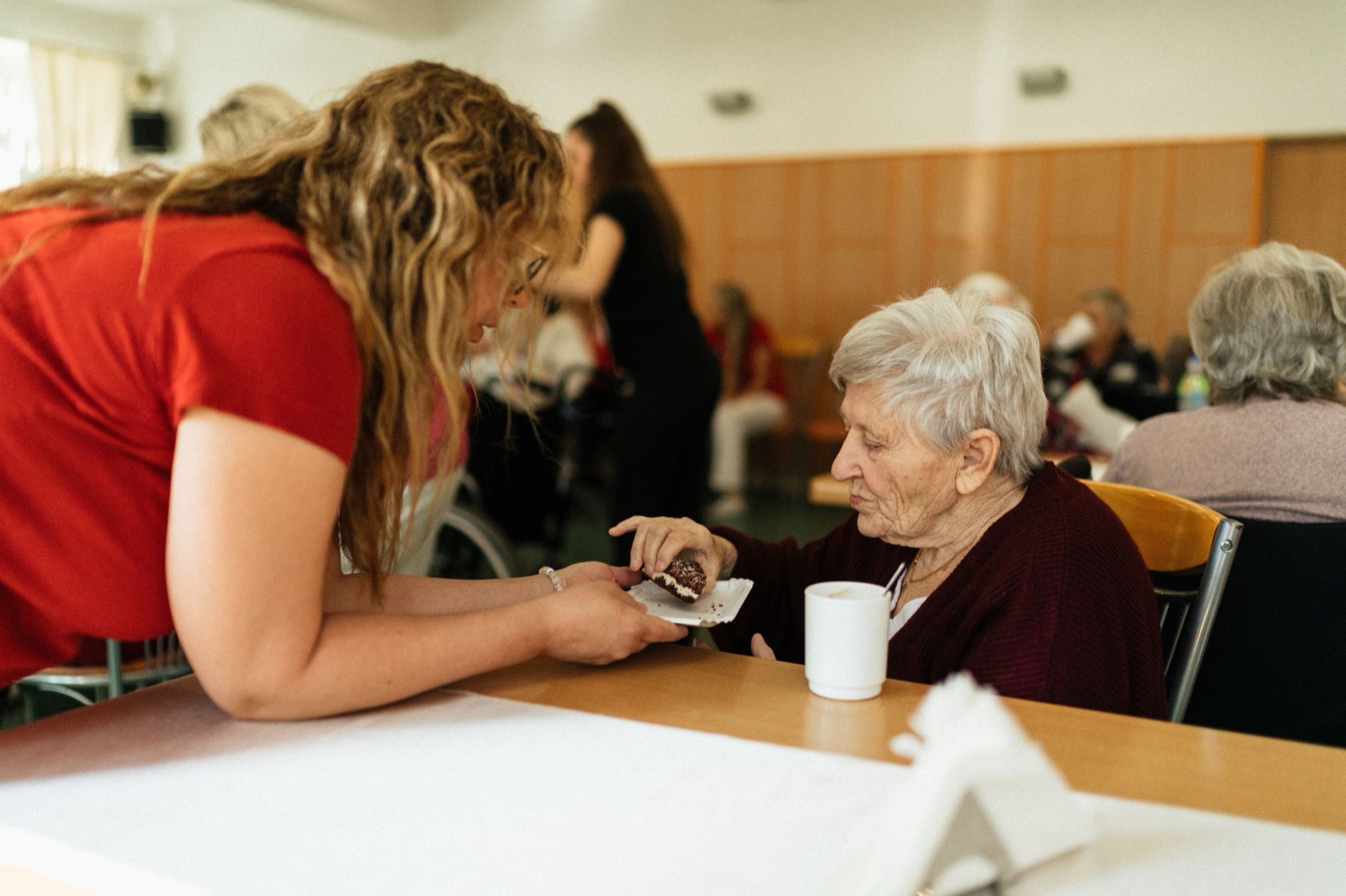 A carer sharing morning tea with a resident