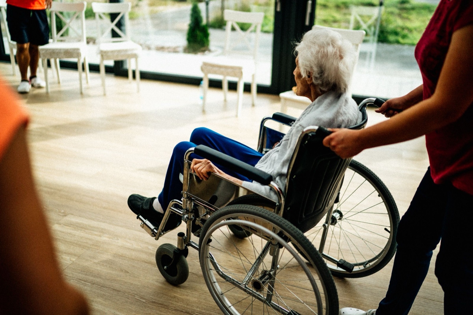 A carer walking with a resident in a day room